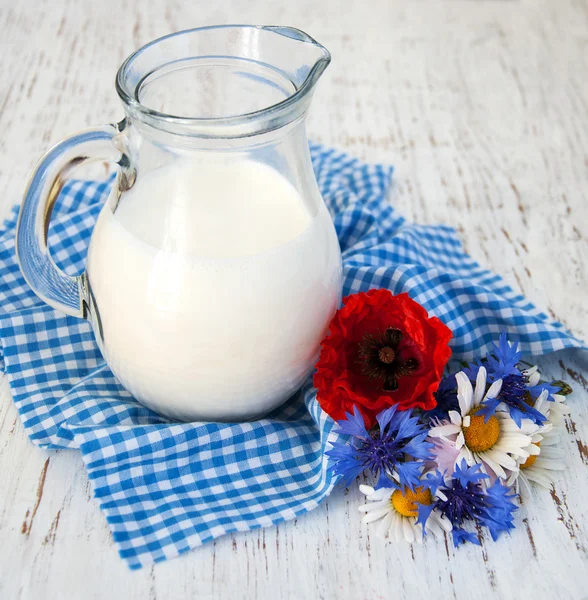 Krug Milch und Wildblumen — Stockfoto
