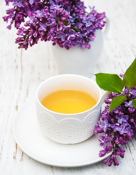 Cup of tea and lilac flowers — Stock Photo, Image