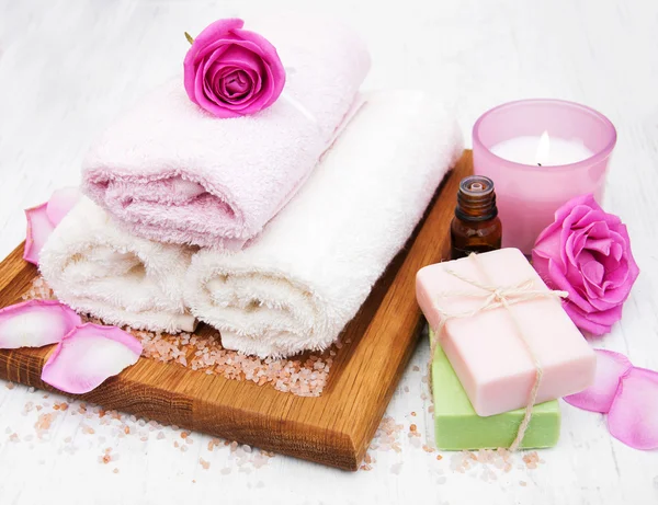 Asciugamani da bagno, candele e sapone con rose rosa — Foto Stock