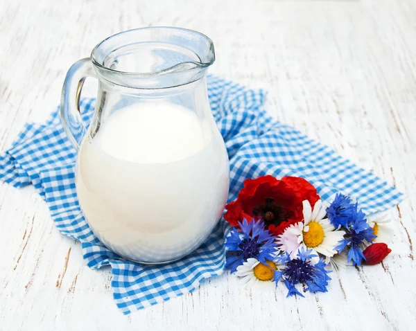 Krug Milch und Wildblumen — Stockfoto