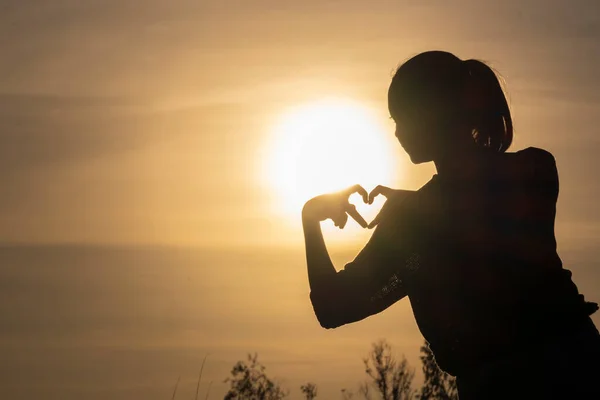 Silhueta Menina Uso Dedo Fazer Coração Com Belo Pôr Sol — Fotografia de Stock