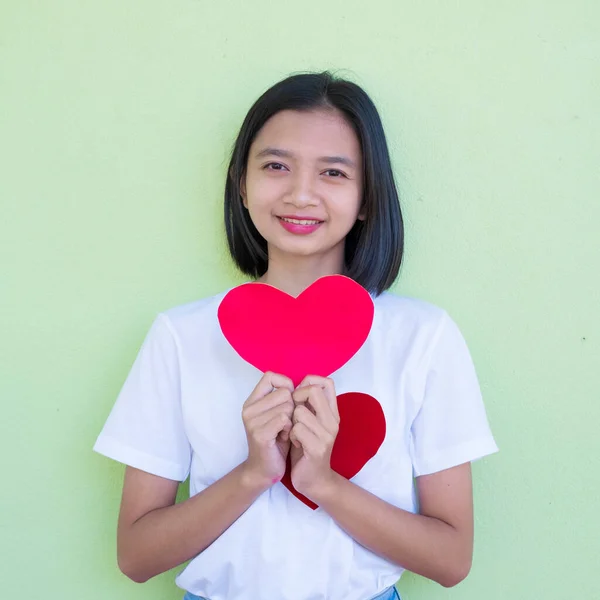 Счастливая Молодая Азиатская Девушка Держит Красное Бумажное Сердце Зеленом Фоне — стоковое фото