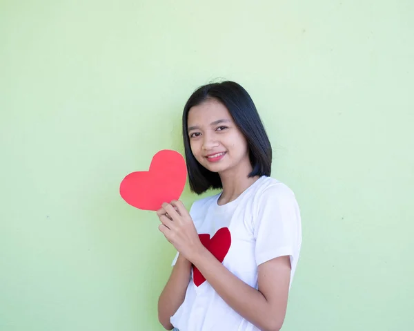 Menina Asiática Feliz Detém Coração Papel Vermelho Fundo Verde — Fotografia de Stock