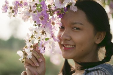 Güzel mor çiçekli Asyalı kız portresi.