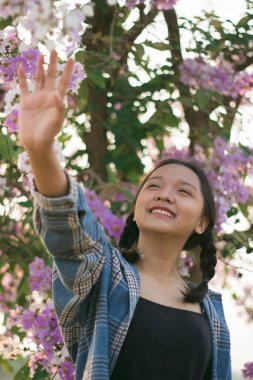 Güzel mor çiçekli Asyalı kız portresi.