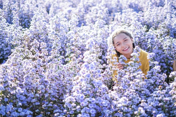紫のマルグリットの花の美しい女の子 — ストック写真