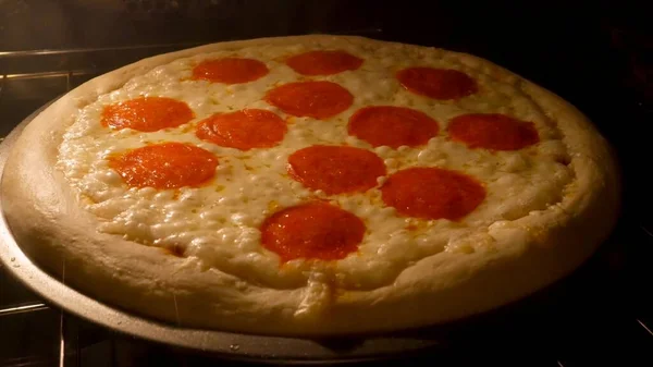 Pepperoni pizza fırında pişiyor.