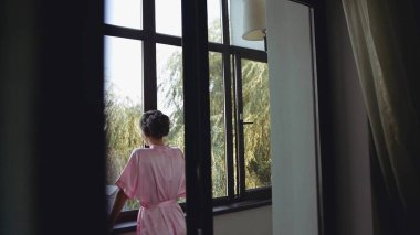 Pencerenin önünde duran biri.