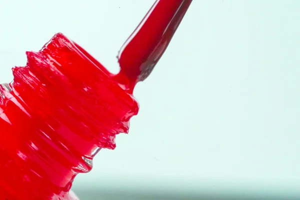 Kırmızı elbiseli genç, parlak bir kadın, tırnaklarını kırmızı cila ile boyuyor, lüks bir randevuya hazırlanıyor.