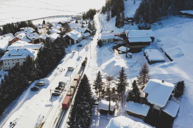 Karla kaplı yamaçta kar kayağı yapan bir adam.