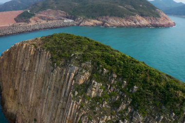 Bir yamacın yakınında bir su kütlesinin yanında.