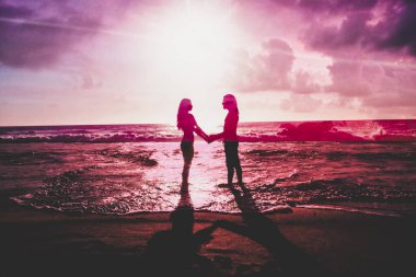 Gün batımının önünde duran biri.