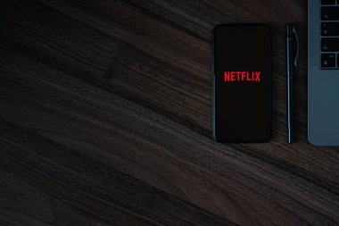 Nisan 2020 - ABD: Netflix logosu ahşap bir masa üzerinde koyu bir arkaplan, mobil uygulama kopyalama alanı.