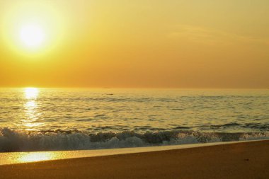 Okyanusun kıyısındaki bir sahilde gün batımı