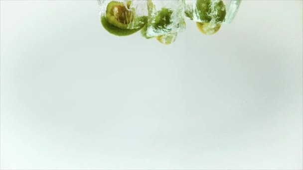 Aguacate cae al agua con ráfagas de fruta fresca — Vídeo de stock