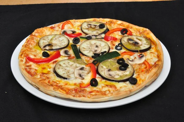 Une pizza assise sur une assiette de nourriture — Photo