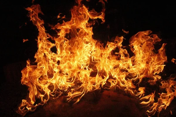 Um incêndio em uma sala escura com fogueiras de São João no fundo — Fotografia de Stock