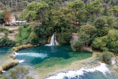 Turkuaz nehir ve yabanıllarla çevrili güzel bir köy manzarası