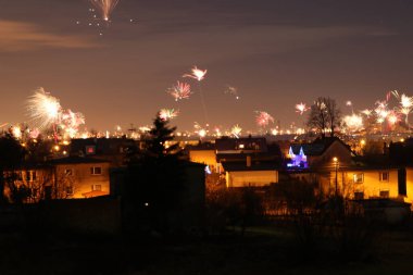 Yeni yılda bir şehrin üzerinde patlayan havai fişek manzarası