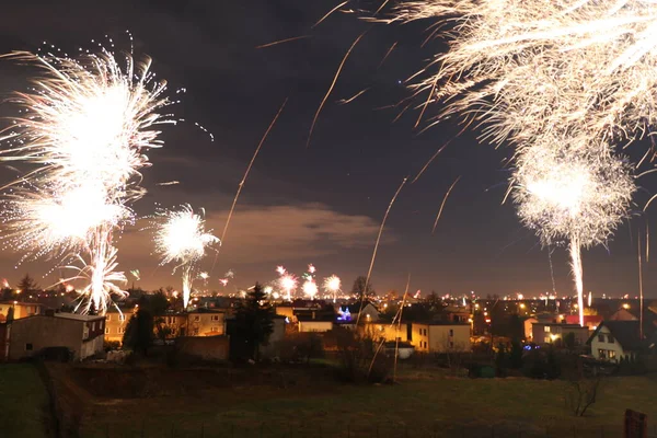 Yeni yılda bir şehrin üzerinde patlayan havai fişek manzarası