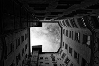 Gökyüzünün tepesinde bir apartmanın ortasında siyah ve beyaz açılı bir manzara.