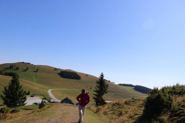 Dağlık çayırlarda yürüyüş yapan bir kişinin görüntüsü