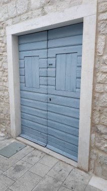 Eski bir taş duvardaki mavi kapıya bak.