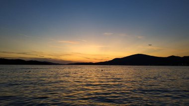 Arkaplanda siluet adaları olan bir günbatımında görünüm