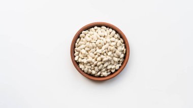 Kahverengi seramik kasede beyaz fasulye. Bir kase beyaz fasulye. Beyaz arkaplandaki donanma, cannellini fasulyesi üst görüntü izole edilmiş.