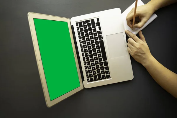 Yeşil ekran açık defter ve dizüstü bilgisayar. Not defterine not alan genç bir kadın. Çalışmak, öğrenmek. Klavye. online kurs. Corona virüsü karantinaya alındı. çevrimiçi toplantı, webinar.