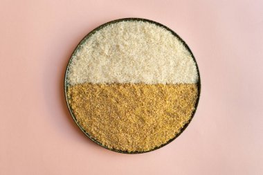 Bir tabak pirinç ve geleneksel Türk bulgur bulgur, açık pembe çıplak arka planda büyük buğday taneleri. Tabak ikiye bölündü ve bir tarafı pirinç, diğer tarafı bulgur ile dolu..