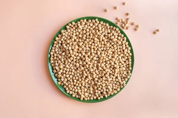 Plate Chickpea Light Pink Background Green Plate Dry Legumes Scattered — Φωτογραφία Αρχείου