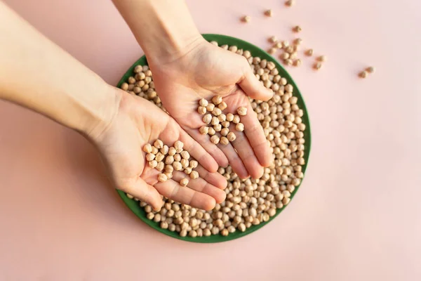 Plato Garbanzos Semillas Mano Sobre Fondo Rosa Claro Plato Verde — Foto de Stock