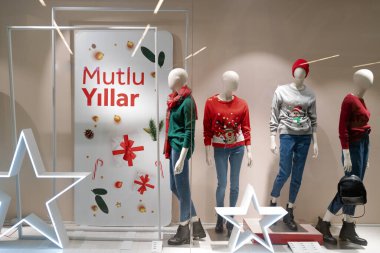 İstanbul 'daki alışveriş merkezinde noel ve yeni yıl heyecanı. Yeni yıl için markalar dekore edilmiş pencereler. Renkli ışıklar, çirkin Noel kazakları, mankenler, dekorasyon, yeşil, kırmızı ve altın sarısı.