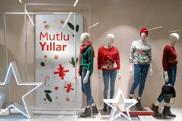 İstanbul 'daki alışveriş merkezinde noel ve yeni yıl heyecanı. Yeni yıl için markalar dekore edilmiş pencereler. Renkli ışıklar, çirkin Noel kazakları, mankenler, dekorasyon, yeşil, kırmızı ve altın sarısı.