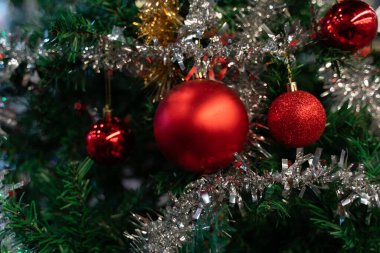 Süslü bir Noel ağacında asılı kırmızı toplar. Noel ve yılbaşı ağacı süslemesi. Spruce, kapat. 2021