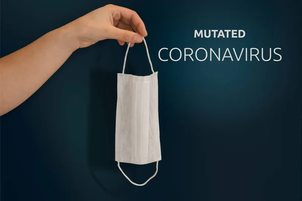 Yeni koronavirüs mutasyonu. Mutasyona uğramış koronavirüs. Mesaj at. Elinde tıbbi bir maske vardı. Siyah arka plan. konsept