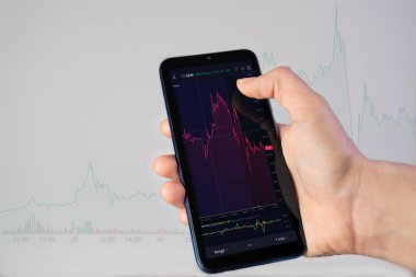 İstanbul, TR - 29 Ocak 2021 GameStop Şirketi 'nin borsa endeksi telefon ekranında. Kadın telefonu elinde tutuyor ve borsa çizelgesinin önünde borsa yatırım başvurusunu kullanıyor.