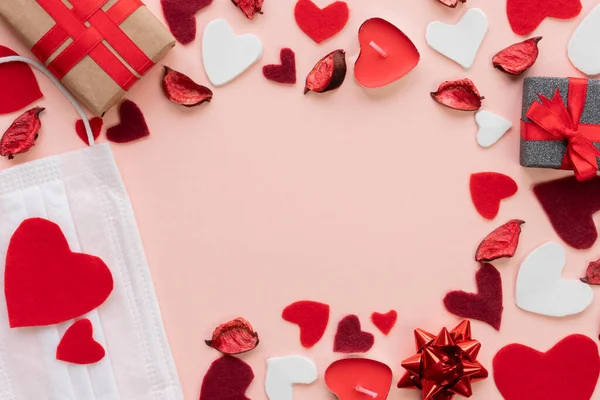 Sevgililer Günü için kompozisyon 14 Şubat Yumuşak pembe arka plan çerçeve tıbbi maske hediyeler mum güller kırmızı kalpler düz düz bir görüş alanı 2021 Love konsepti covid-19