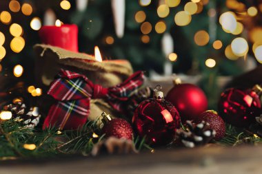 Bulanık yılbaşı ağacının üstünde kırmızı Noel süsleri var.