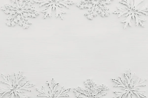 Wallpaper with white snowflakes on white wooden background