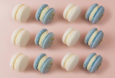 Masada beyaz ve mavi badem kurabiyeleri, pembe arka planda badem kurabiyeleri