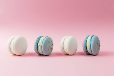 Masada beyaz ve mavi badem kurabiyeleri, pembe arka planda badem kurabiyeleri