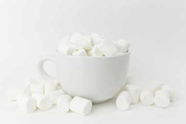 Beyaz arka plandaki bardakta lokum var.