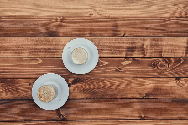 Dua cangkir kopi di kayu coklat teras latar belakang — Stok Foto