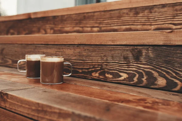 Dua cangkir kopi di kayu coklat teras latar belakang — Stok Foto