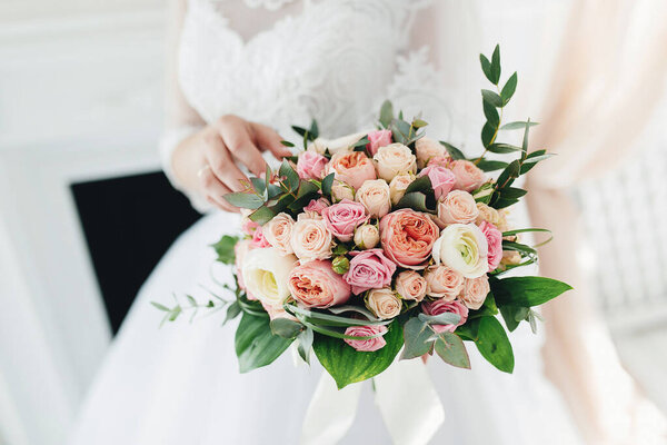 Bride in white dress is holding wedding bouquet
