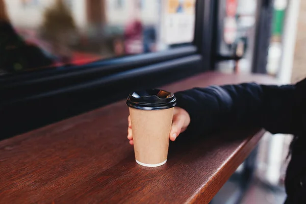 Gadis memegang cangkir kertas kopi di tangan dekat kafe — Stok Foto