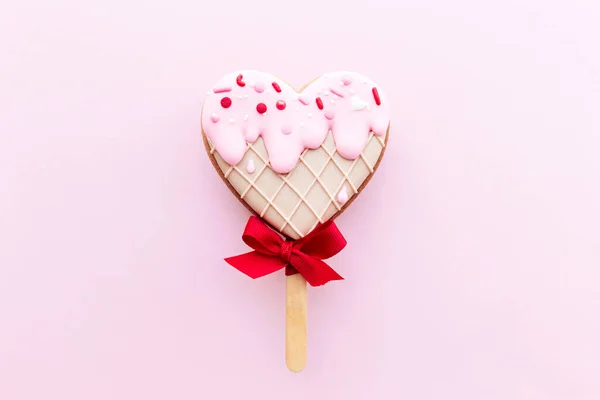 아이스크림을 녹인 심장이 빵 쿠키를 만들고 있어. 발렌타인 카드. 핑크 색 배경 — 스톡 사진