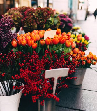 Bir mağaza vitrininde farklı çiçekler boş fiyat etiketleriyle gösterilir